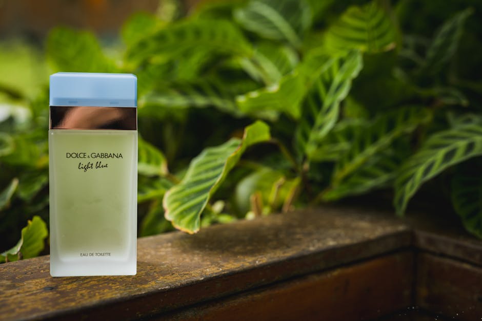 Dolce & Gabbana Light Blue perfume bottle set against lush green tropical leaves, capturing freshness and elegance.