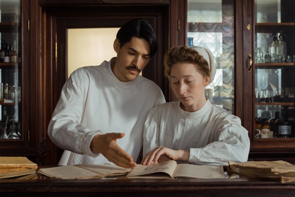 Two pharmacists in period attire examine medical texts at a vintage pharmacy counter.