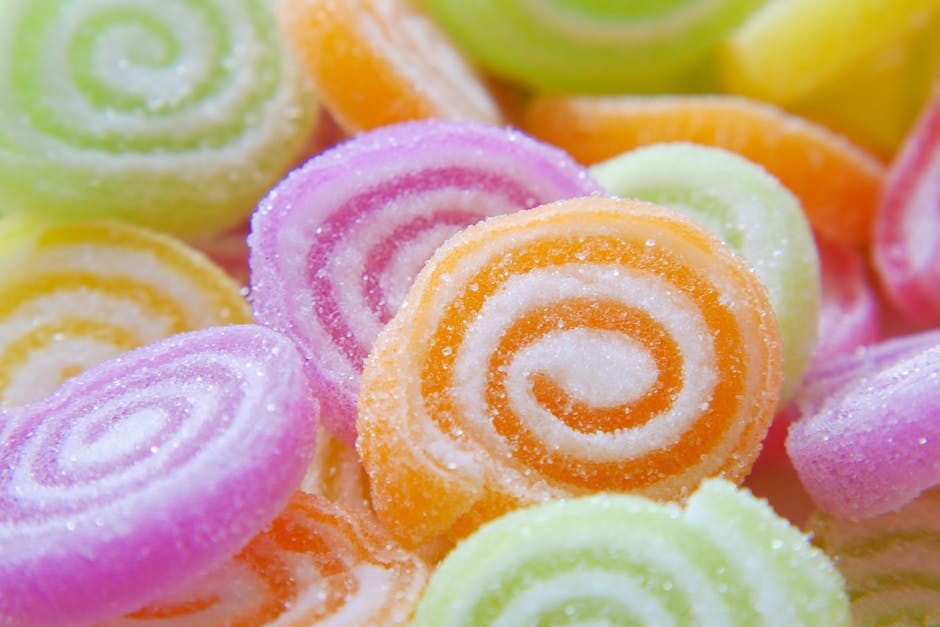 Close-up of colorful sugary swirled gummy candies in various bright hues.