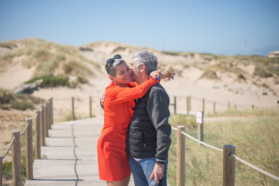Loving couple embraces on a sunny boardwalk in Portugal, showcasing warmth and affection.