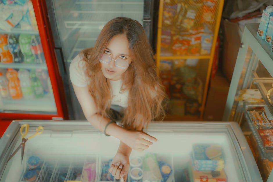 Young woman stands at a fridge in an Indian retail store. Overhead view.