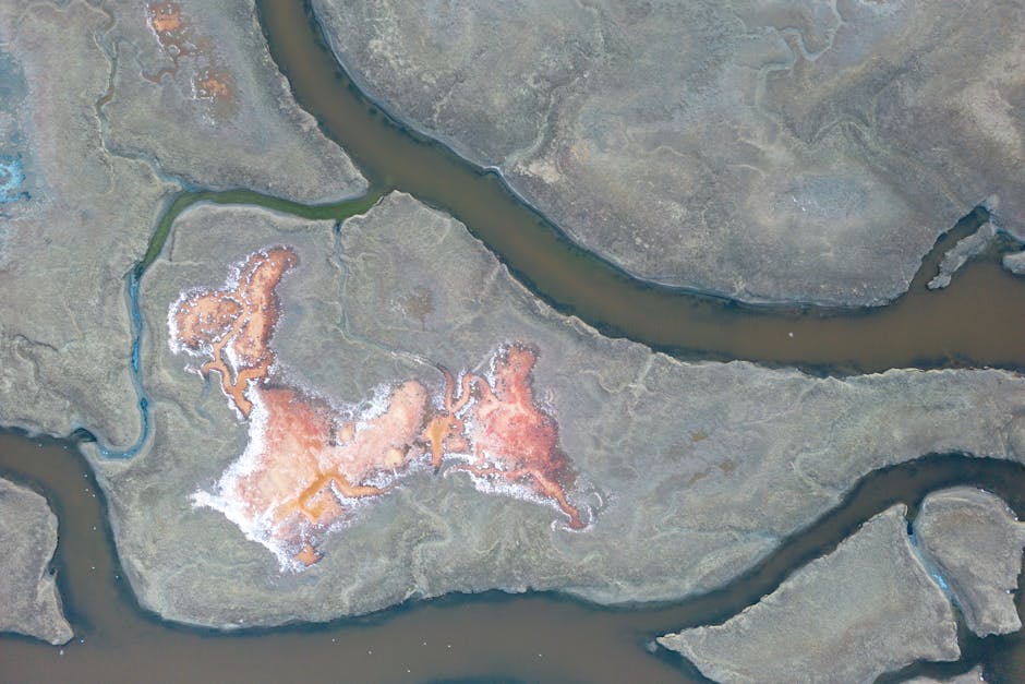 Stunning aerial shot of salt ponds creating abstract, colorful patterns in a natural landscape.
