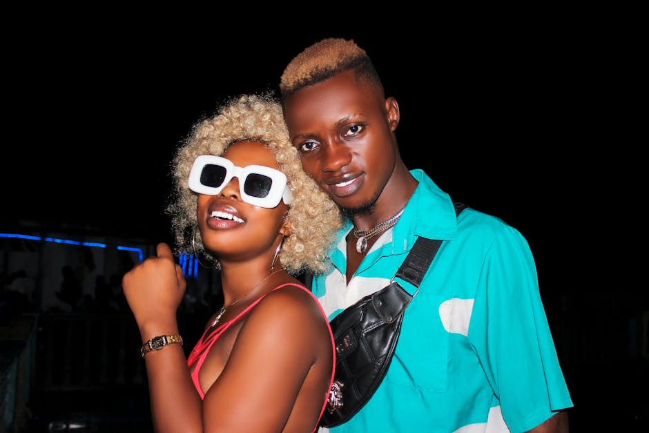 Young couple with sunglasses posing confidently at night.