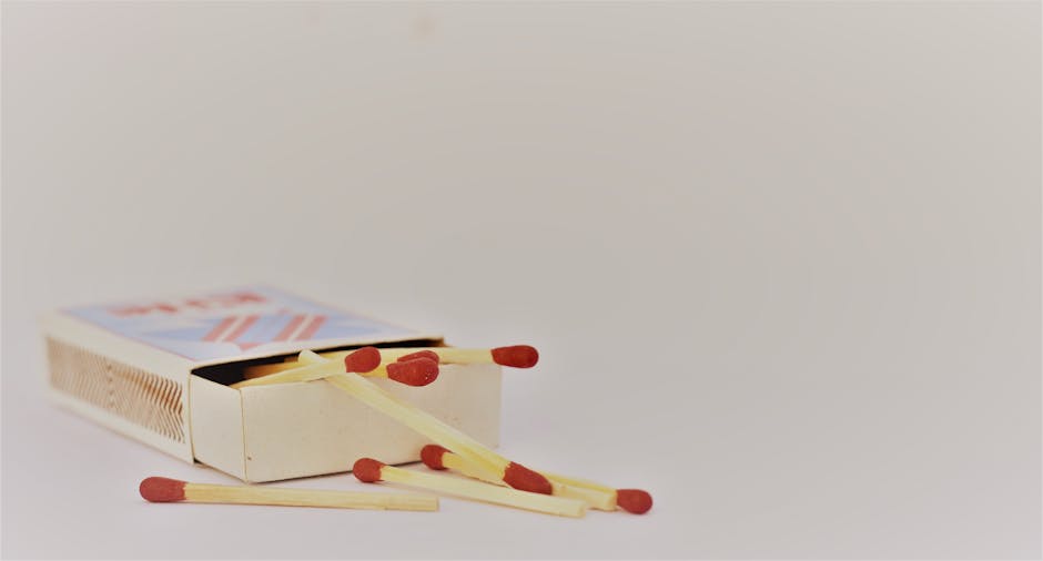 A close-up of an open matchbox with scattered matches on a white surface. Ideal for safety themes.
