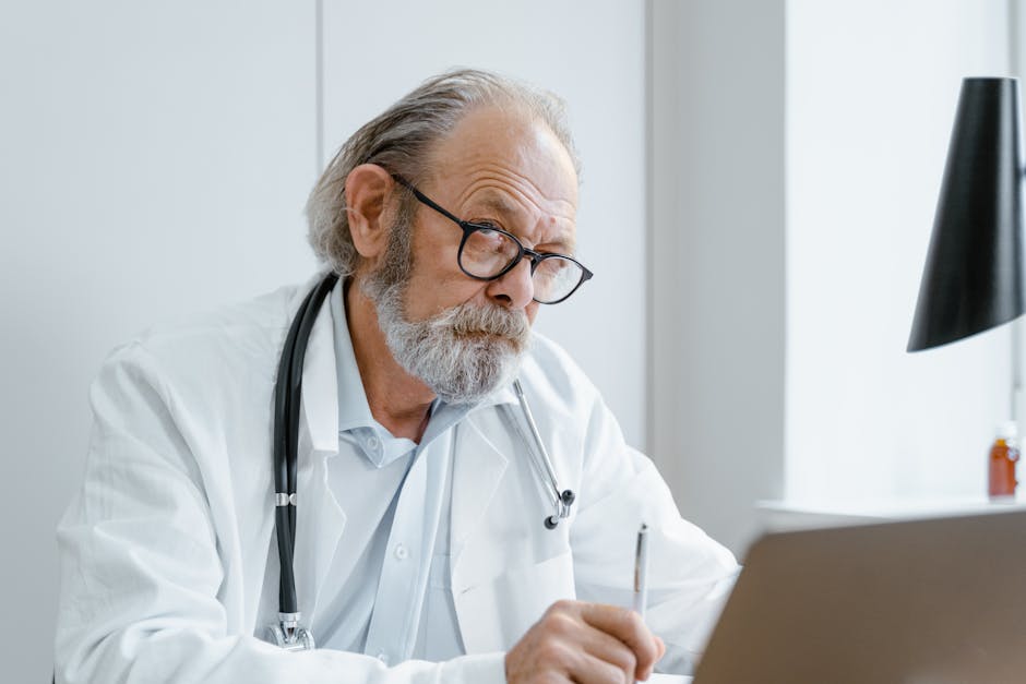 Elderly doctor using telemedicine for virtual consultation in office.