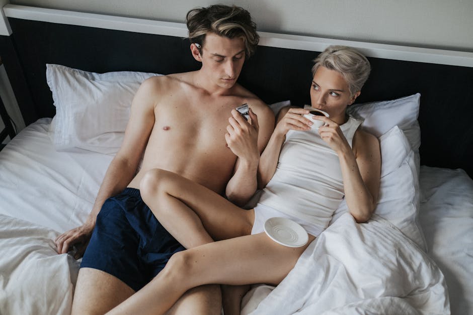 A couple enjoying coffee in bed, creating a warm and intimate atmosphere.