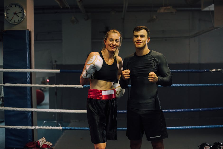 Two athletes standing in a boxing ring, ready for training session.