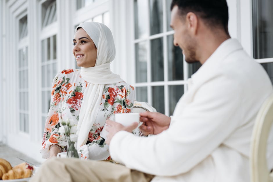 A romantic couple shares a warm coffee moment outdoors in a vibrant setting, highlighting their cultural elegance and connection.