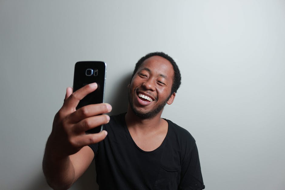 Happy man capturing a cheerful selfie with smartphone indoors.