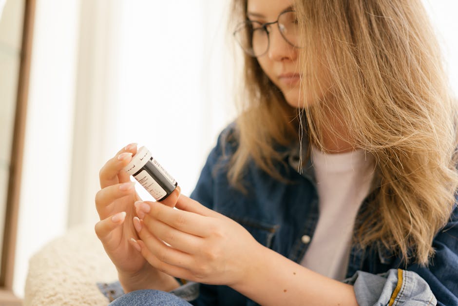 A woman carefully examines a medication bottle indoors, emphasizing health care attention.