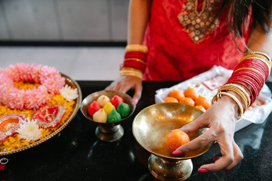Woman celebrating with traditional Indian sweets and rituals, showcasing cultural attire and food.