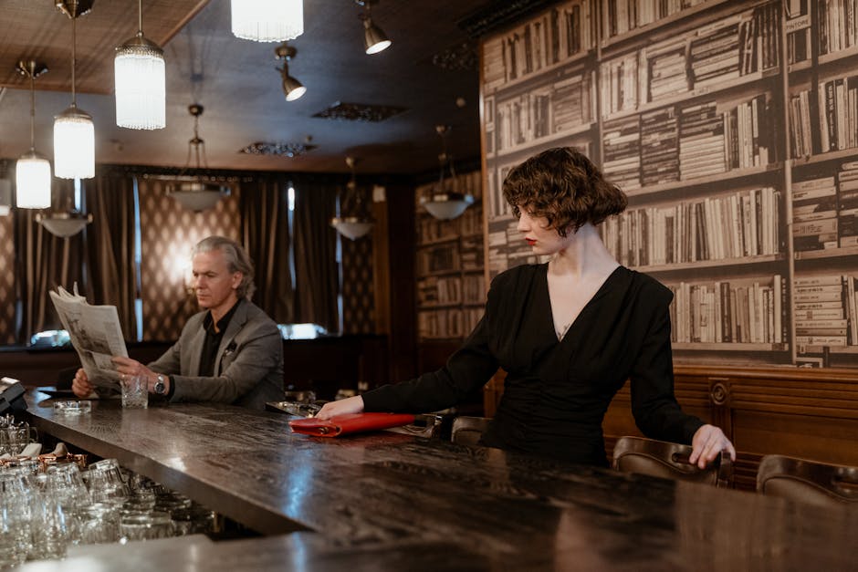 Stylish indoor scene with a man reading a newspaper and a woman in a black dress at a bar.