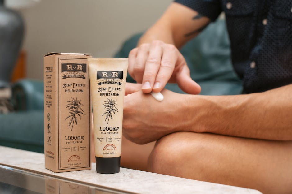 Person applying hemp-infused cream with packaging visible, promoting skincare benefits.