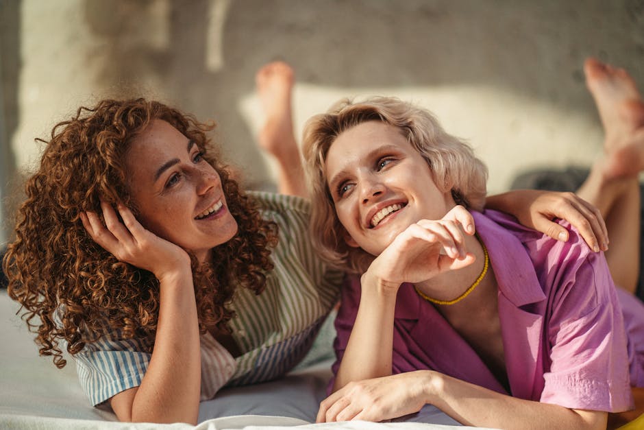 Smiling couple enjoying a relaxing moment together in a sunlit room, showcasing love and happiness.