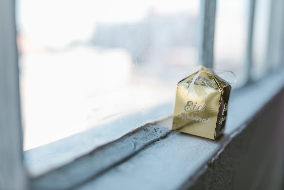 A golden Eid Mubarak gift box on a window sill, symbolizing celebration and tradition.
