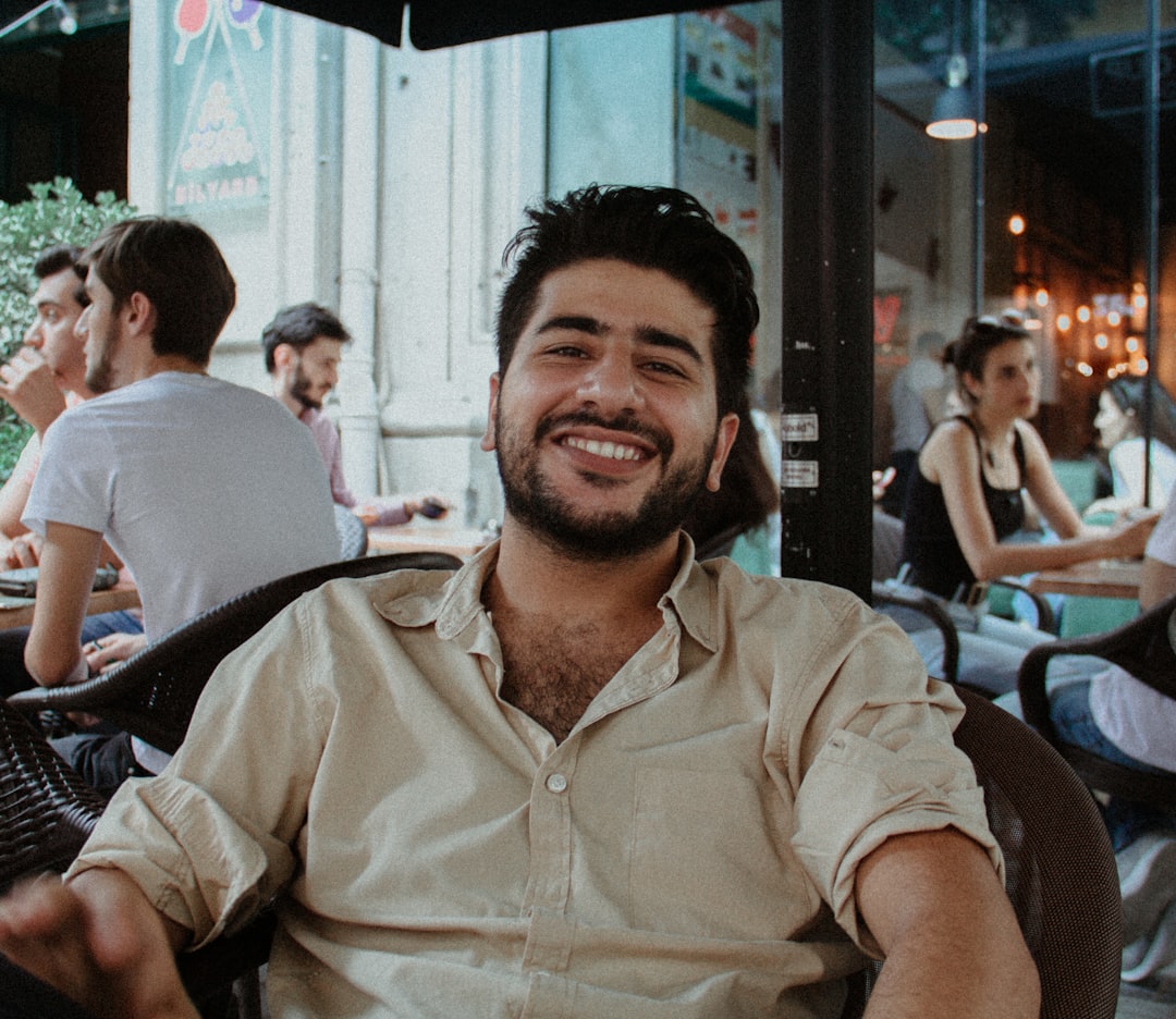 man in beige button up shirt smiling
